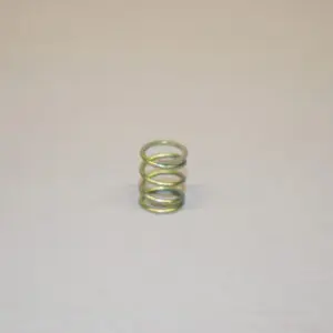 A metal spring sitting on top of a white surface.