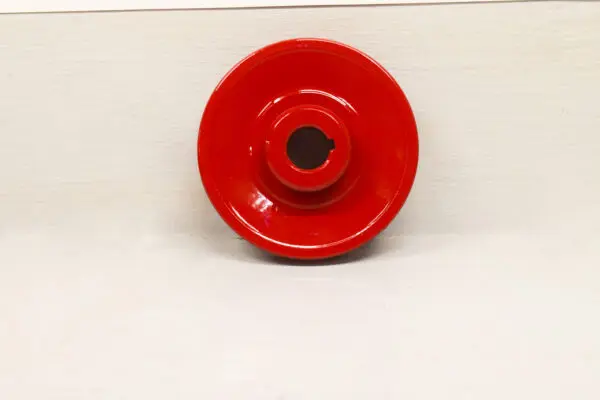 A Toro Wheel Horse Pulley sitting on top of a white wall.
