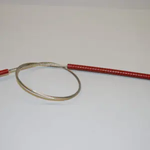 A red and silver wire is next to a metal object.