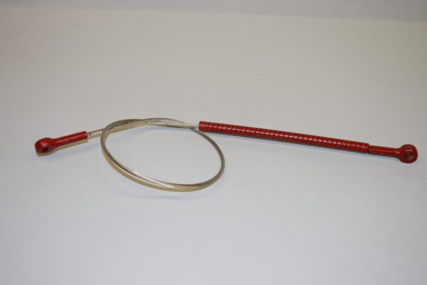 A red and silver wire is next to a metal object.