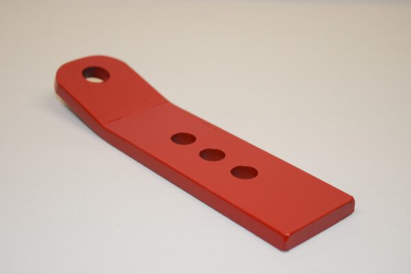 A red plastic Toro Wheel Hitch Insert for Slot Hitch with holes on it.