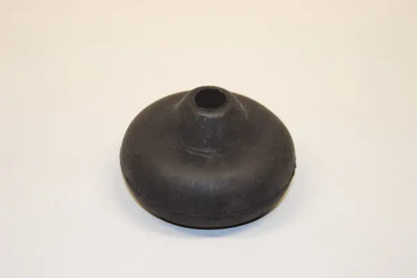 A black rubber object sitting on top of a white surface.