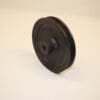 A black plastic pulley sitting on top of a white table.
