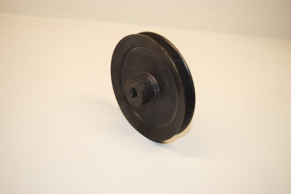 A black plastic pulley sitting on top of a white table.
