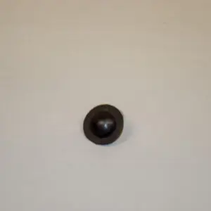 A black ball is sitting on the wall.