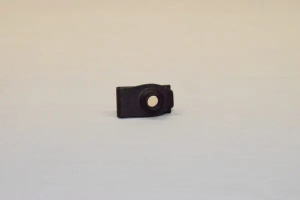 A black plastic clip on the side of a white table.