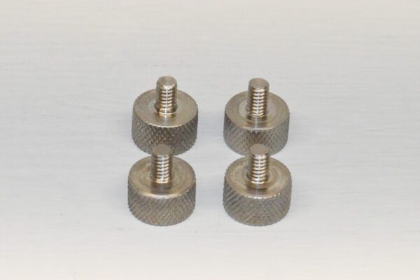 A set of four metal knobs with one missing the top.