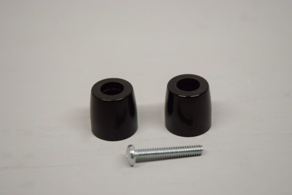 A pair of black plastic end caps next to a screw.