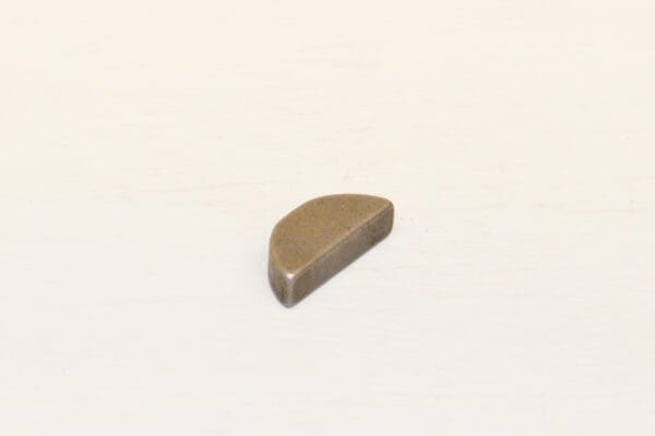 Gray, flat, triangular-shaped stone on surface.