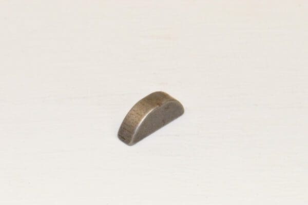 A small piece of metal on a white surface with key number / 5 Woodruff Key for Wheel Horse.