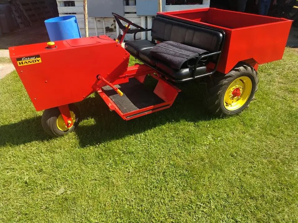 A red and yellow tractor parked in the grass on display at the gallery.