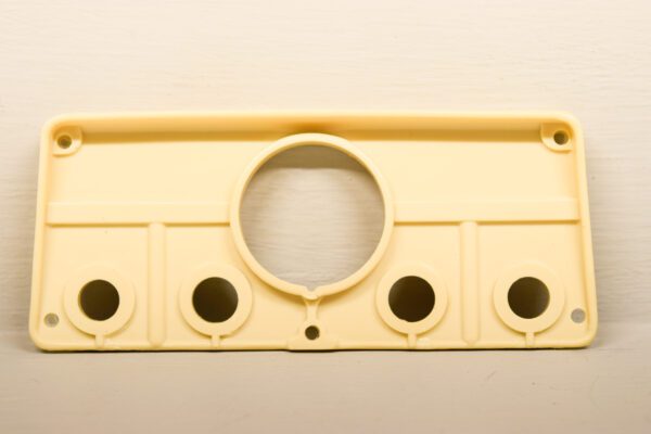 A yellow plastic plate with holes on it, suitable for use as a 701 Dash Plate for Wheel Horse.