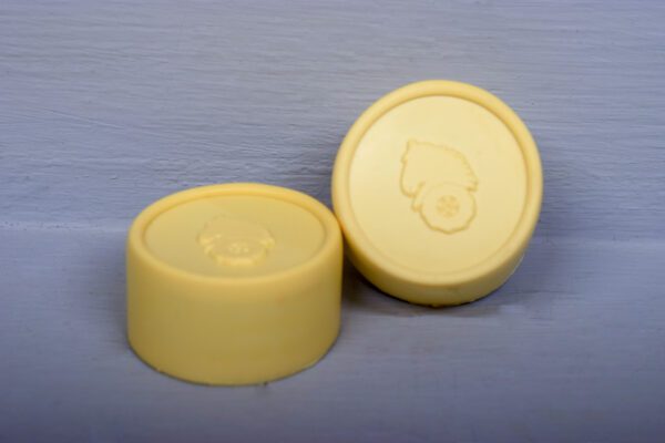 Two yellow soap containers on a white surface with (2) Ivory Hub Caps Molded Logo D-Series Wheel Horse.