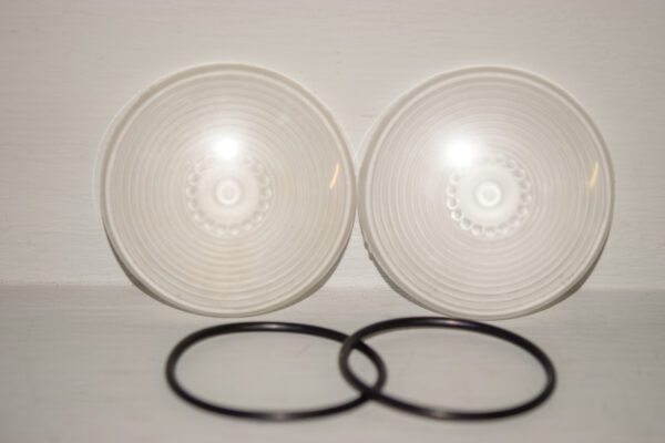 Two clear plastic lids and a pair of black rubber rings.