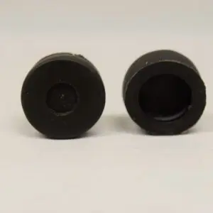 A pair of black rubber plugs sitting on top of a table.
