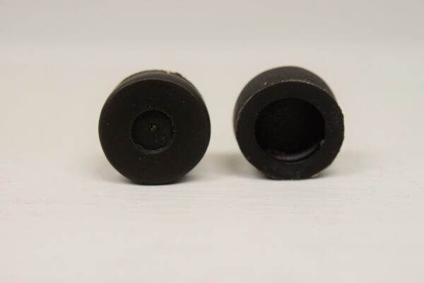 A pair of black rubber plugs sitting on top of a table.