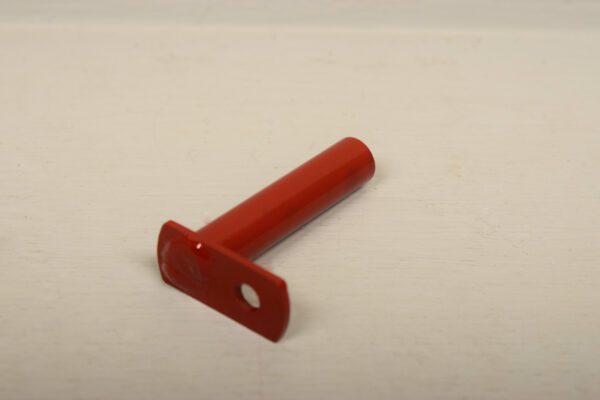 A red plastic handle on a white surface, suitable for the Axle Pivot Pin for Wheel Horse.