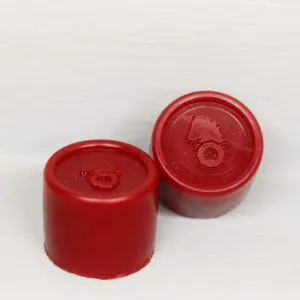 Two red plastic caps sitting next to each other.
