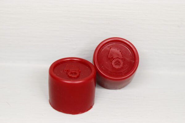 Two red plastic caps sitting next to each other.