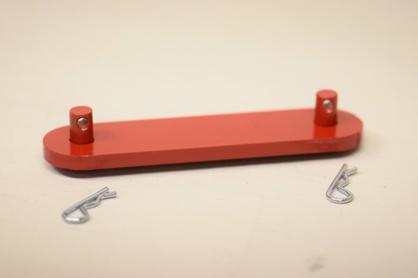 A red board with two metal clips on top of it.