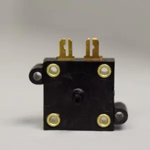 A black and gold electrical switch on top of a white table.