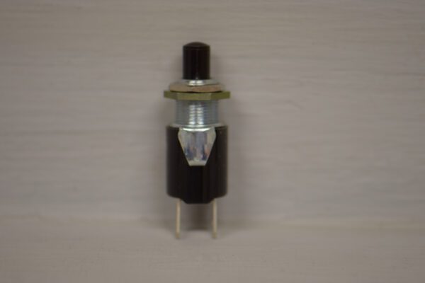 A small black Toro Wheel Horse replacement push button switch on a white surface.