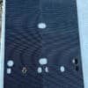 Black textured board with holes and slits.